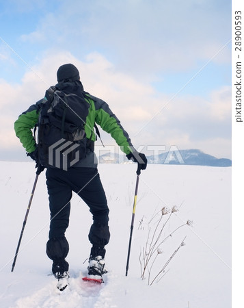 Man with snowshoes take a rest in snow. Hiker Man with snowshoes take a rest in snow. Hiker 28900593