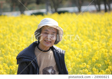 A woman smiling at a rape field 28900821