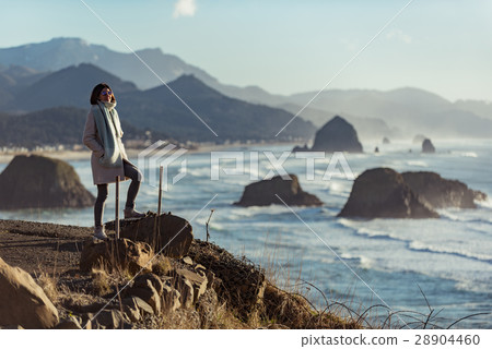 Smiling female situating on coastline Smiling female situating on coastline 28904460