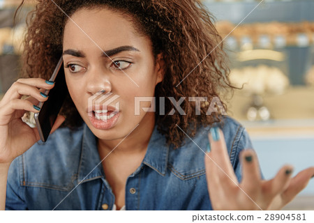 Upset mulatto girl talking on mobile 28904581
