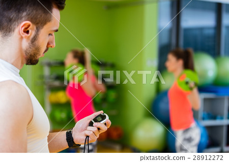 Two girl exercising at the gym with a personal 28912272