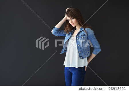 Young thoughtful woman on dark background Young thoughtful woman on dark background 28912631