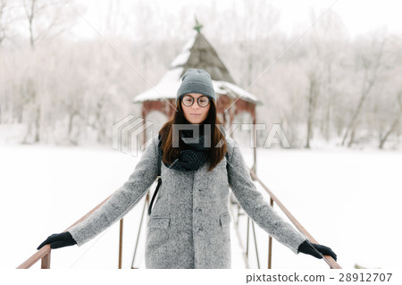 Girl in gray coat on a bridge in winter 28912707