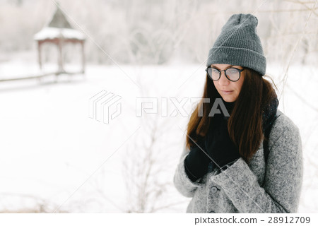 Girl in gray coat on a bridge in winter 28912709