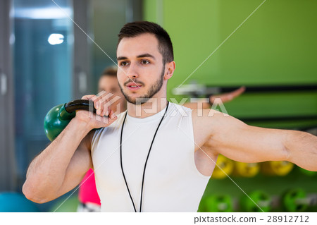 Kettlebells swing exercise man and woman workout Kettlebells swing exercise man and woman workout 28912712