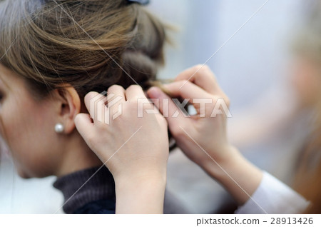 Young woman getting her hair done before party 28913426