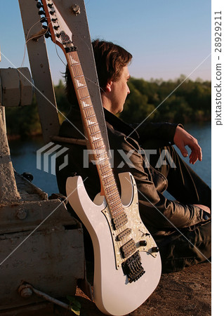 Man with an electric guitar in the industrial 28929211