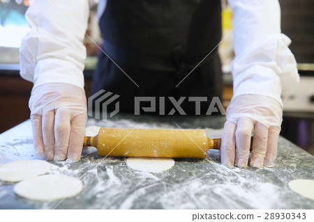 Male chef uses ingredients for preparing flour products on kitch Male chef uses ingredients for preparing flour products on kitch 28930343