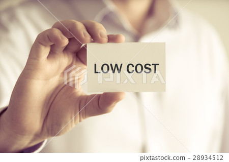 Businessman holding LOW COST message card 28934512