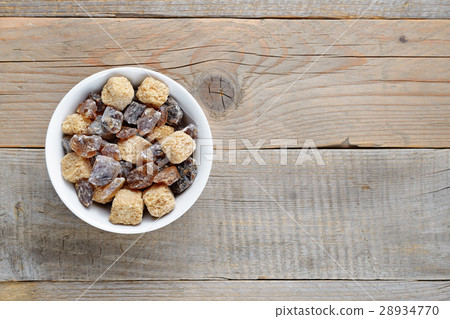 Brown sugar in bowl on wooden table 28934770