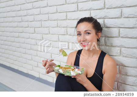 Fit healthy woman in sportswear eating a fresh Fit healthy woman in sportswear eating a fresh 28934859