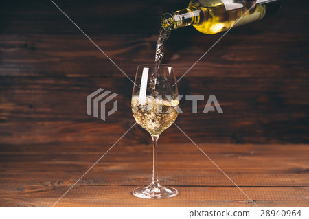 Pouring white wine from a bottle in a close up Pouring white wine from a bottle in a close up 28940964