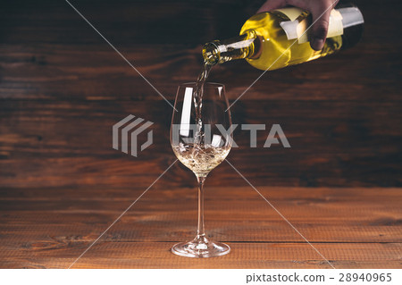 Pouring white wine from a bottle in a close up Pouring white wine from a bottle in a close up 28940965