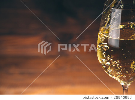 Pouring white wine from a bottle in a close up Pouring white wine from a bottle in a close up 28940993