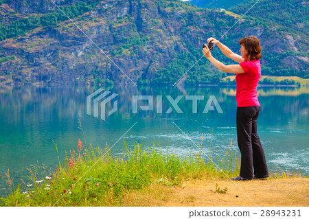 Tourist taking photo at norwegian fjord 28943231