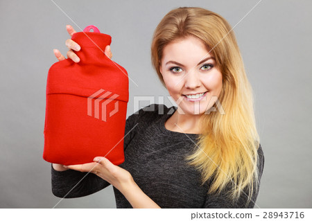 Woman holding warm red hot water bottle 28943716