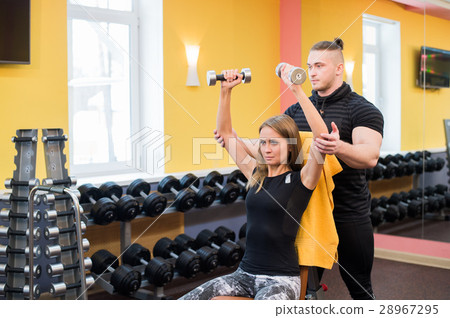 Woman with her personal fitness trainer in the gym 28967295