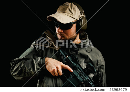 man in cap holding assault rifle 28968679