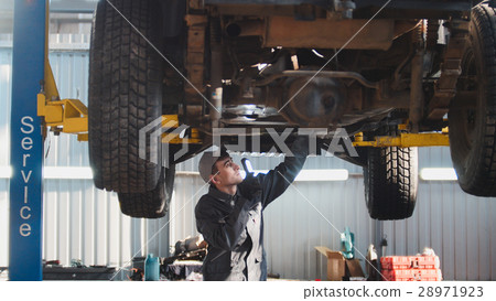 Car service - a mechanic checks the suspension of Car service - a mechanic checks the suspension of 28971923