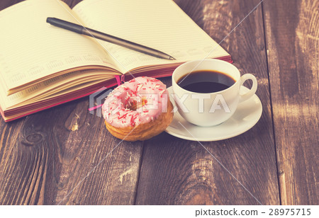 Coffee, donut and notepad on wooden background Coffee, donut and notepad on wooden background 28975715