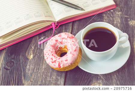 Coffee, donut and notepad on wooden background 28975716