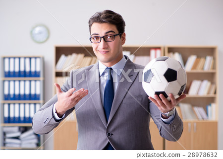 Businessman with football ball in office Businessman with football ball in office 28978632