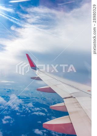 Wing of an airplane flying above the clouds . 28980329