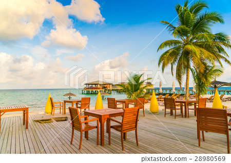 Table and chairs at restaurant in tropical Maldives island . Table and chairs at restaurant in tropical Maldives island . 28980569