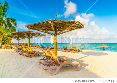 Beach chairs with umbrella at Maldives island, white sandy beach and sea . 28980635