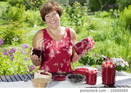 Happy woman with pots of raspberry jam Happy woman with pots of raspberry jam 28988869