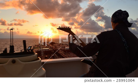 A man playing guitar and singing at sunset on boar A man playing guitar and singing at sunset on boar 28991004