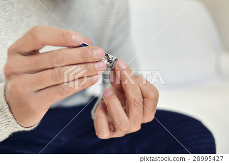 young man cutting his fingernails 28995427