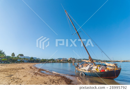Abandoned & stranded sail boat on the beach. Abandoned & stranded sail boat on the beach. 28995792