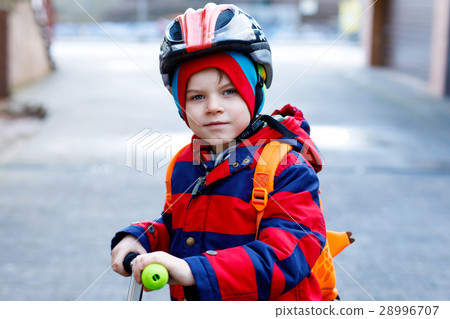 Cute little preschool kid boy riding on scooter 28996707