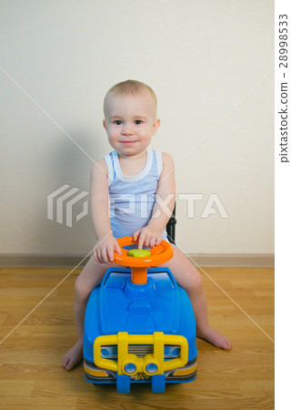 Cute Baby boy driving a toy car at home Cute Baby boy driving a toy car at home 28998533