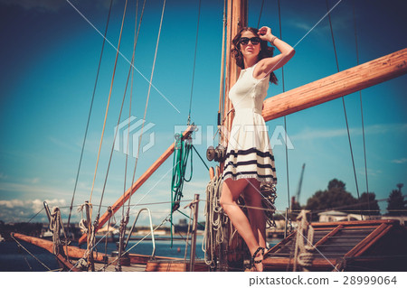 Stylish wealthy woman on a luxury wooden regatta Stylish wealthy woman on a luxury wooden regatta 28999064