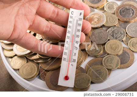 Thermometer in hand beside Turkish Lira coins 29008731