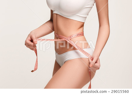The girl taking measurements of her body, white The girl taking measurements of her body, white 29015560