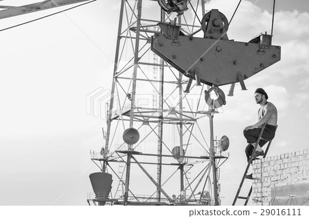Retro construction worker climbing a ladder while Retro construction worker climbing a ladder while 29016111
