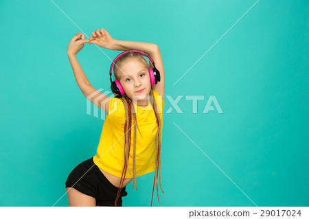 The attractive girl with headphones on blue The attractive girl with headphones on blue 29017024