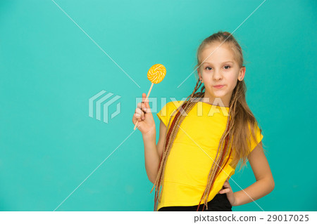 The teen girl with colorful lollipop on a blue 29017025