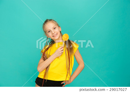 The teen girl with colorful lollipop on a blue The teen girl with colorful lollipop on a blue 29017027
