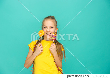 The teen girl with colorful lollipop on a blue The teen girl with colorful lollipop on a blue 29017052