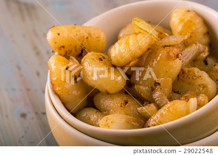 Detail of few pieces of gnocchi with onion 29022548