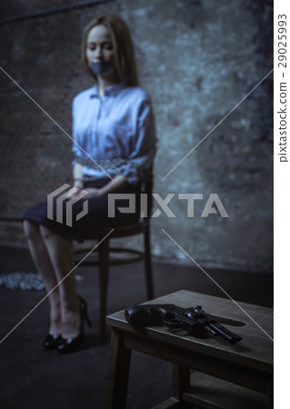 Frightened captured woman waiting in a dark room 29025993