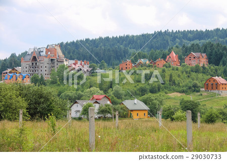 Modern cottages on slopes of forested mountains Modern cottages on slopes of forested mountains 29030733