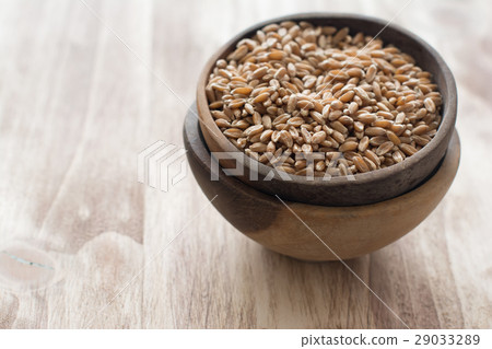 圖庫照片: uncooked spelt in the wooden bowl