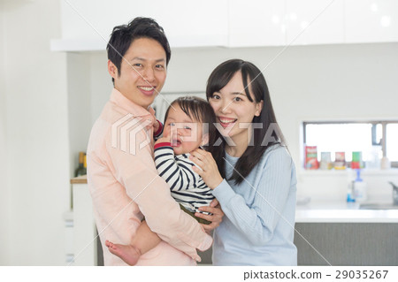 Dad and mom holding a baby 29035267