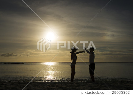 Dusky beach and men's and women's silhouette 29035502