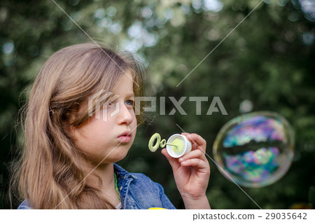 Portrait of cute little girl blowing soap bubbles. Portrait of cute little girl blowing soap bubbles. 29035642